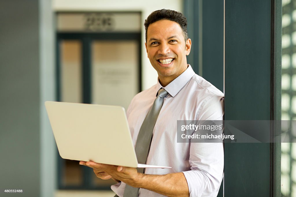 Businessman with laptop in office