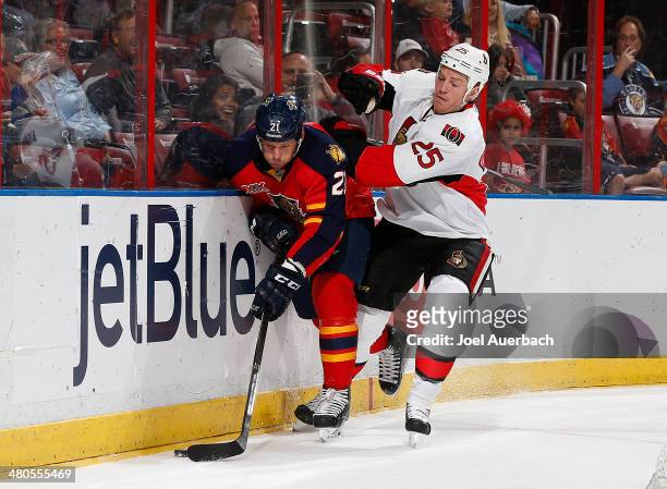 Chris Neil of the Ottawa Senators and Krys Barch of the Florida Panthers fight for control of the puck along the boards at the BB&T Center on March...