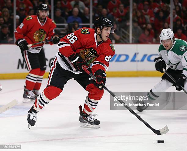 Teuvo Teravainen of the Chicago Blackhawks clears the puck out of the Blackhawks zone past Ryan Garbutt of the Dallas Stars at the United Center on...
