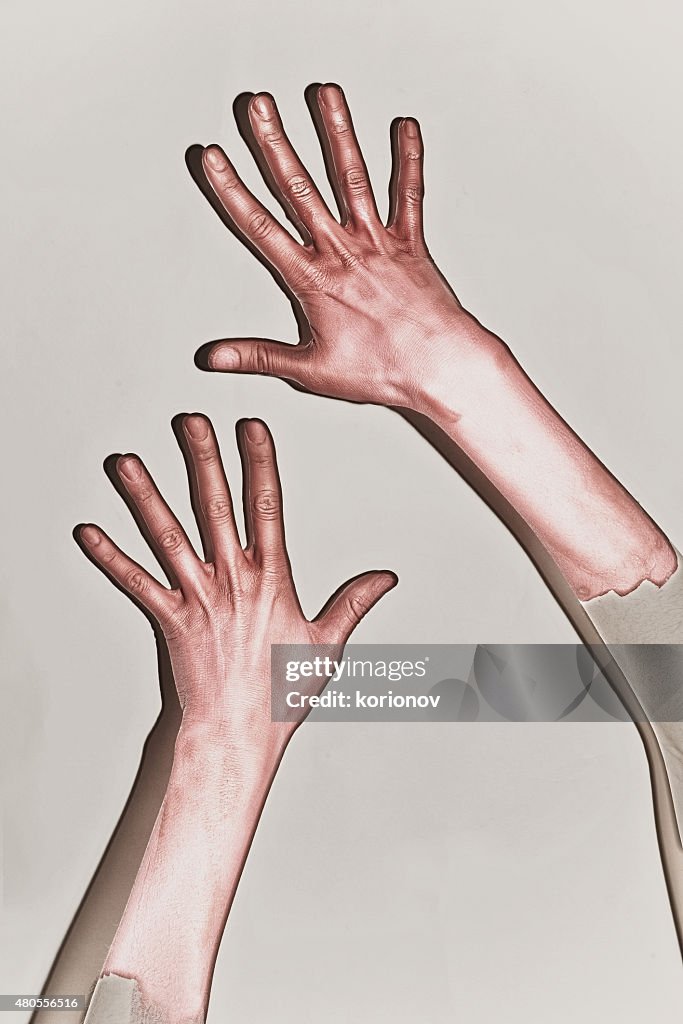 Male hands painted in red paint