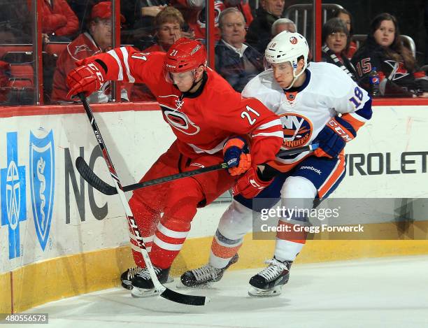 Ryan Strome of the New York Islanders slows up Drayson Bowman of the Carolina Hurricanes while he attempts to take control of the puck along the...