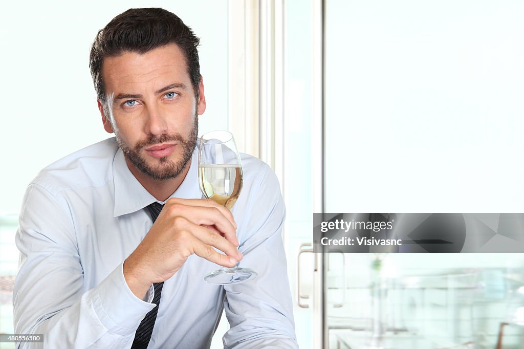 Handsome man drinking a glass of sparkling wine white