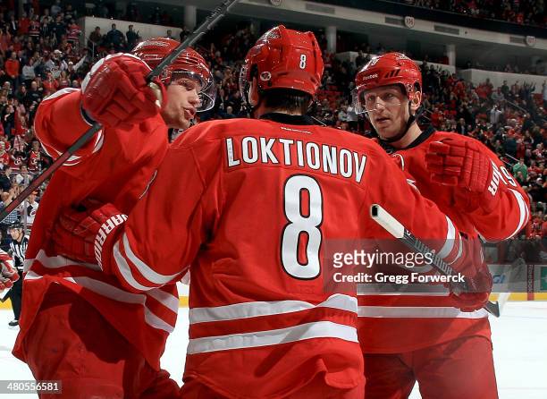 Eric Staal and Jiri Tlusty of the Carolina Hurricanes celebrate a first-period goal scored by Andrei Loktionov against the New York Islanders during...