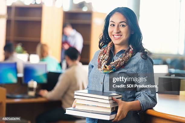 junge college-student in bibliothek bücher ausgeliehen - librarian stock-fotos und bilder