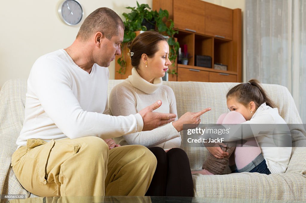 Parents scolding daughter at home