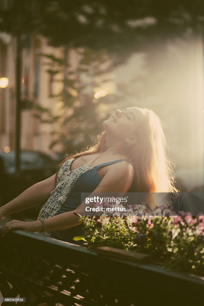 Happy women enjoy summertime in city park backlit shot