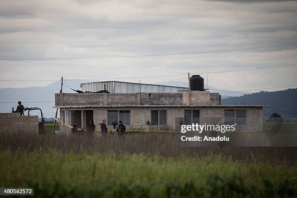 Federal Police officers stand guard outside a half-built house used by El Chapo Guzman to escape from prison near the maximum security prison of...