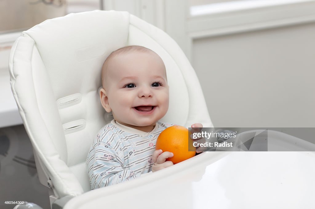 Laughing baby with orange