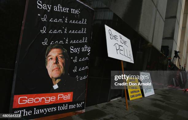 Signage and placards left by protesters can be seen outside Phillip Macquarie Tower on March 24, 2014 in Sydney, Australia. Cardinal Pell is facing...