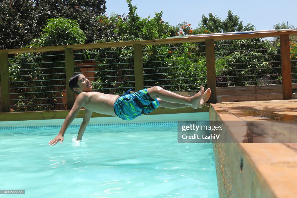 Boy jumps into blue water