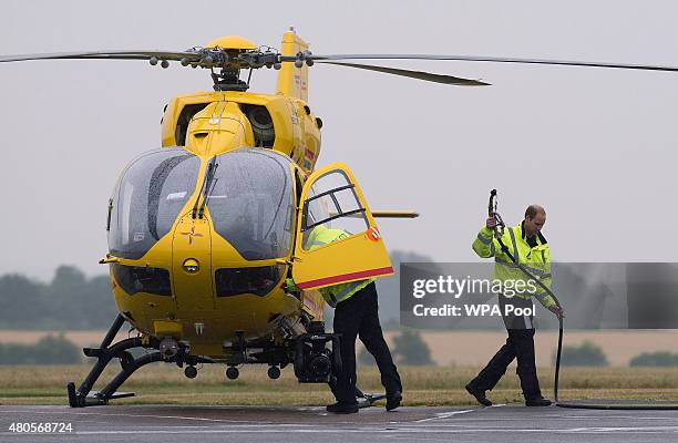 Prince William, The Duke of Cambridge refuels his helicopter as he begins his new job with the East Anglian Air Ambulance at Cambridge Airport on...