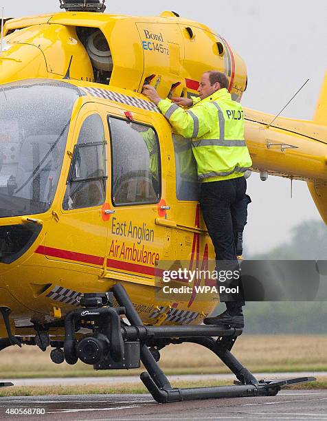 Prince William, The Duke of Cambridge performs checks on his helicopter as he begins his new job with the East Anglian Air Ambulance at Cambridge...