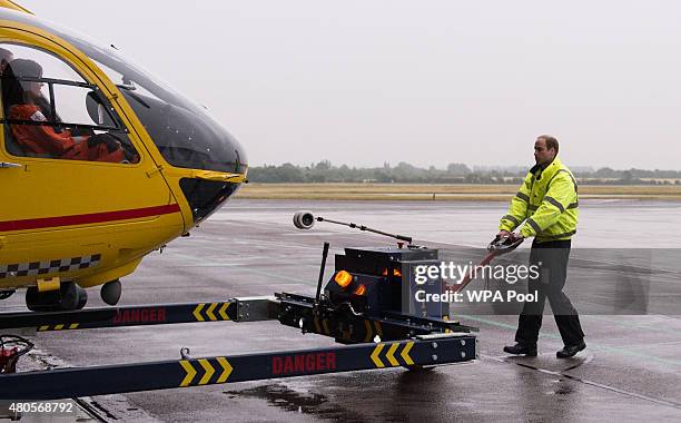 Prince William, The Duke of Cambridge prepares his helicopter as he begins his new job with the East Anglian Air Ambulance at Cambridge Airport on...