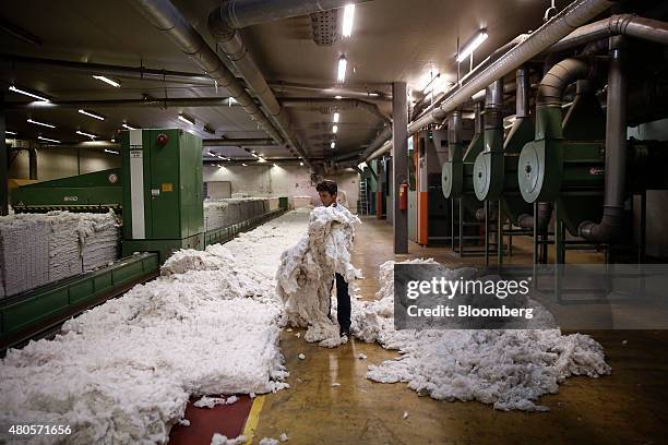 An employee holds a bundle of unprocessed cotton at the Selected Textiles S.A. Processing plant in Farsala, Farsala, Greece, on Friday, July 10,...