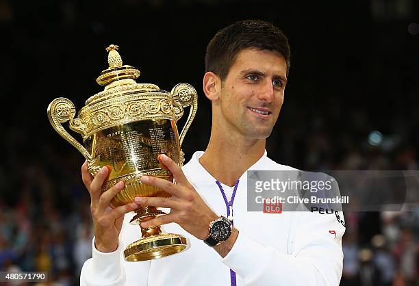 Novak Djokovic of Serbia celebrates with the trophy after winning the Final Of The Gentlemen's Singles against Roger Federer of Switzerland on day...