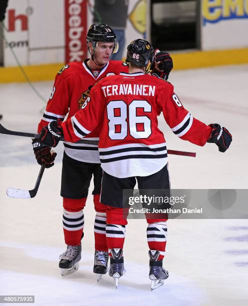 Jonathan Toews of the Chicago Blackhawks congratulates Teuvo Teravainen after Teravainen's NHL debut against the Dallas Stars at the United Center on...