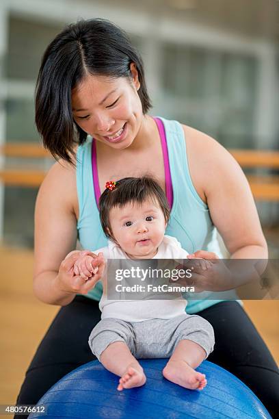 mother and baby at the gym - fitness ball stock pictures, royalty-free photos & images
