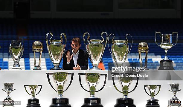 Iker Casillas poses behind trophies he has won during his career in Real Madrid after holding a press conference with Real president Florentino Perez...