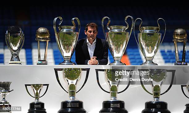 Iker Casillas poses behind trophies he has won during his career in Real Madrid after holding a press conference with Real president Florentino Perez...