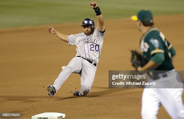 Wilin Rosario of the Colorado Rockies slides into third during the game against the Oakland Athletics at O.co Coliseum on June 30, 2015 in Oakland,...