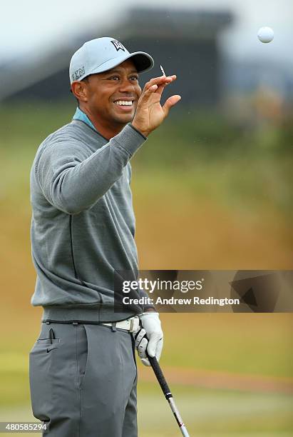 Tiger Woods of the United States smiles while on the driving range ahead of the 144th Open Championship at The Old Course on July 13, 2015 in St...
