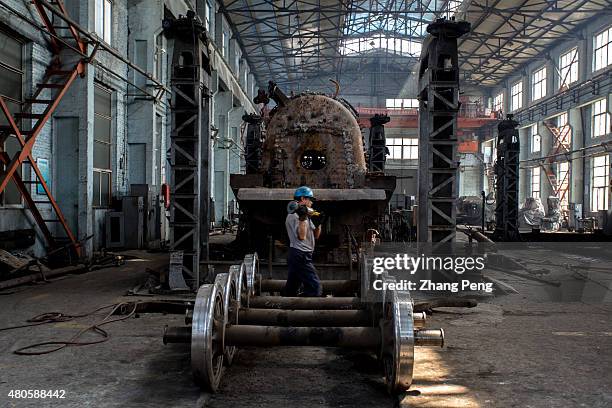 Workers are working in a maintenance factory for steam locomotives. There are less and less steam trains to be repaired and the factory will be...