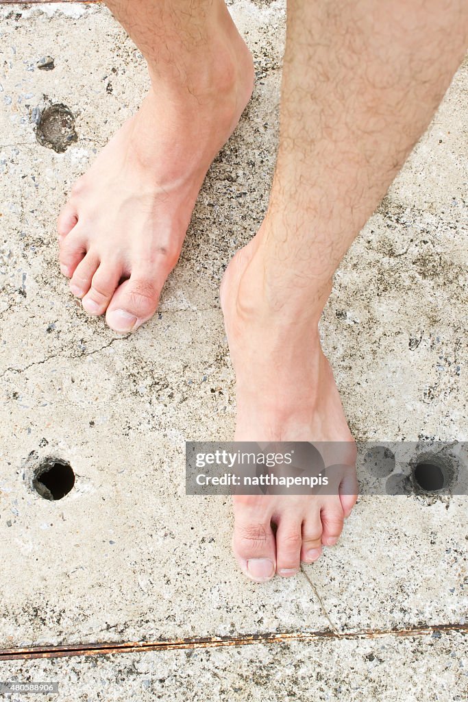Foot on concrete background