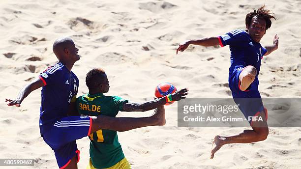 Ibrahima Balde of Senegal is challenged by Ozu Moreira and Teruki Tabata of Japan during the FIFA Beach Soccer World Cup Portugal 2015 Group A match...
