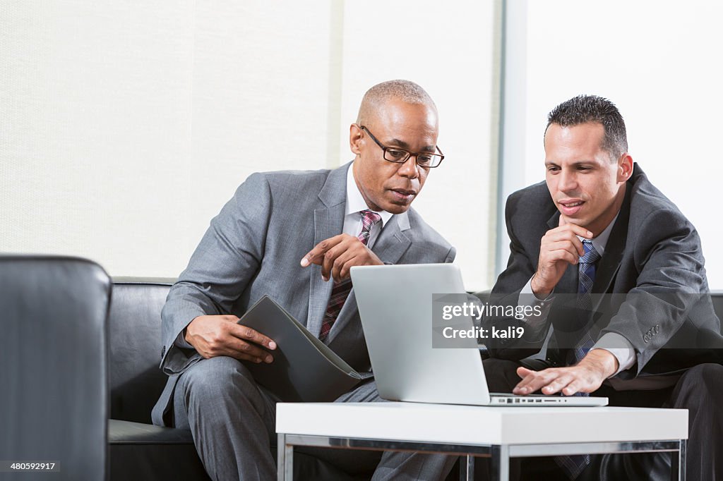 Businessmen using laptop working together on project