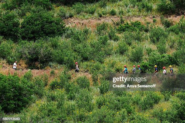 Jogger runs past a group of zipliners as they hike along a trail at Philip S. Miller Park on July 1 in Castle Rock, Colorado. The city is offering...