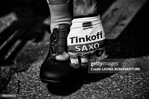 Hand of a rider of Russia's Tinkoff-Saxo cycling team, wearing fingerless gloves, is pictured at the departure village prior to the start of the 166...