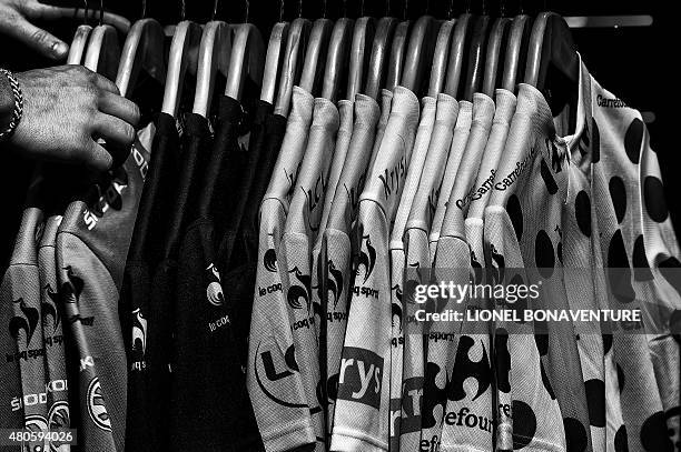 Jerseys with Tour de France colors are displayed for sale at the departure village prior to the start of the 166 km second stage of the 102nd edition...