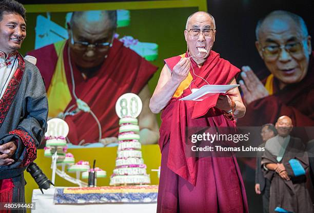 The XIV Dalai Lama eats birthday cake during his 80th birthday celebrations at the 'Jahrhunderthalle' on July 13, 2015 in Frankfurt, Germany.