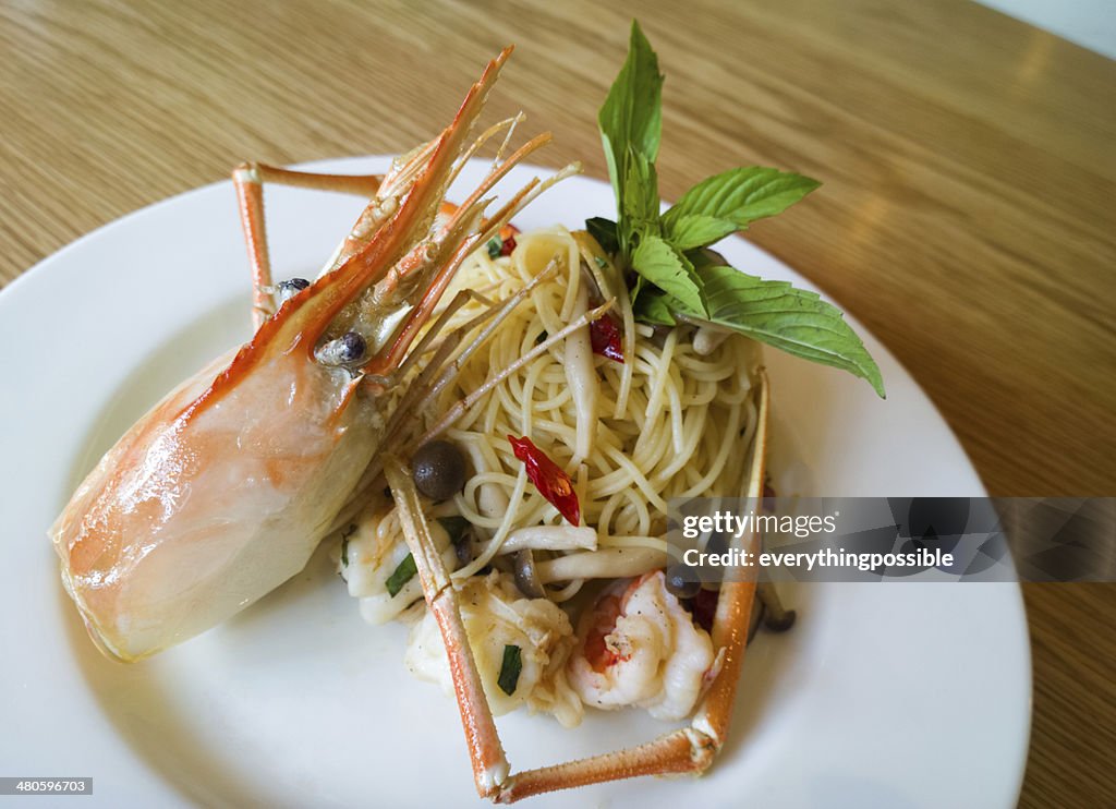 Italian spaghetti pasta and fresh spicy shrimps sauce on wooden