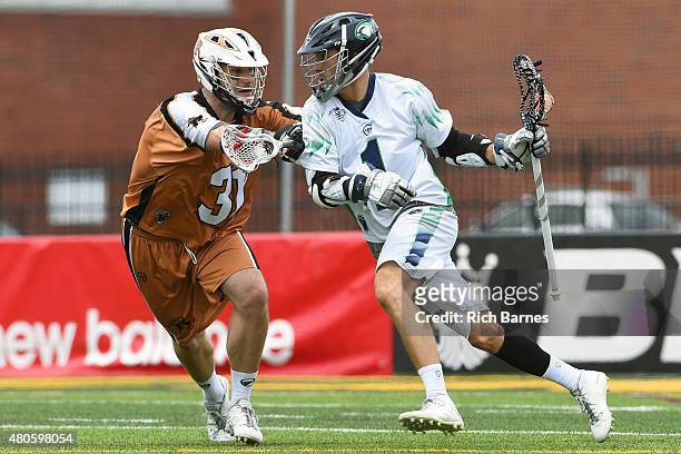 Joe Walters of the Chesapeake Bayhawks dodges to the goal against the defense of John Ranagan of the Rochester Rattlers during the first quarter at...
