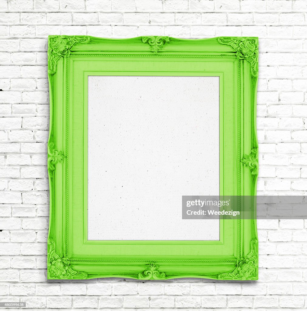 Blank green Vintage photo frame on white brick wall