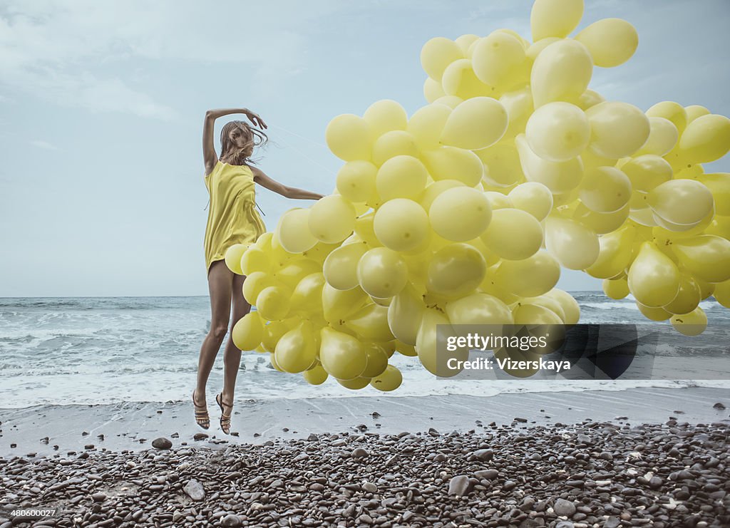 Ragazza con palloncini gialli