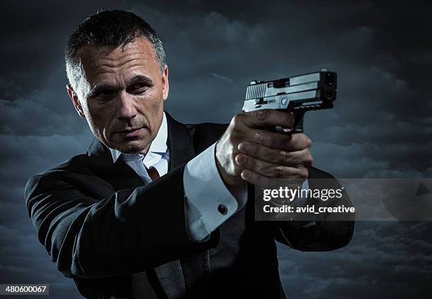 secret agent armed with handgun - man watching fire stock pictures, royalty-free photos & images