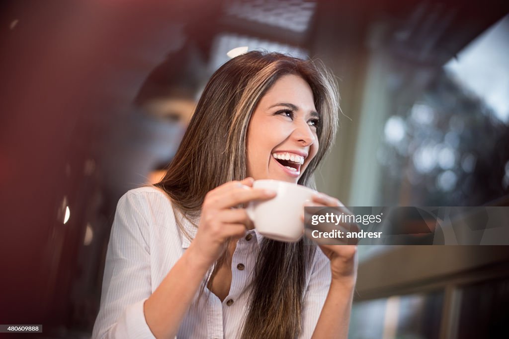 Happy woman having a cup of coffee