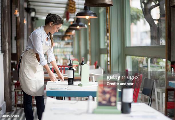 waitress setting tables at a restaurant - waiting tables stock pictures, royalty-free photos & images