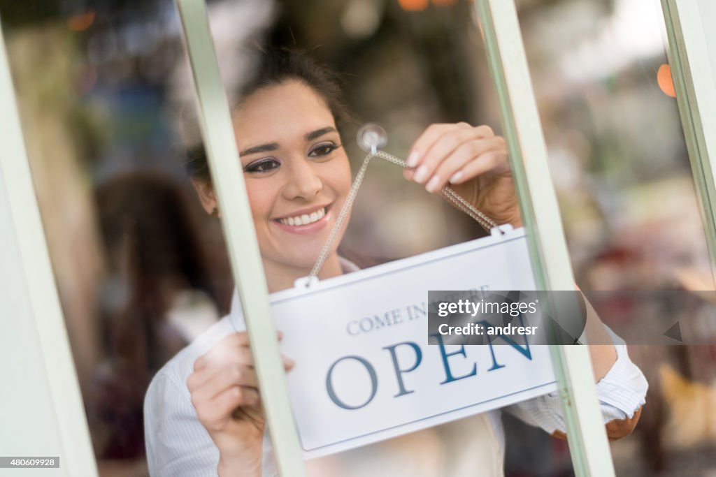 Waitress hanging an open sign at a restaurant