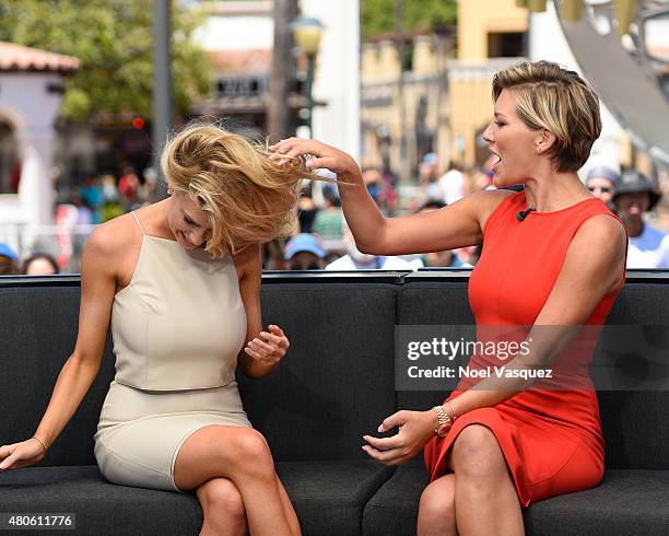 Charissa Thompson feels Charlotte McKinney's hair at "Extra" at Universal Studios Hollywood on July 13, 2015 in Universal City, California.