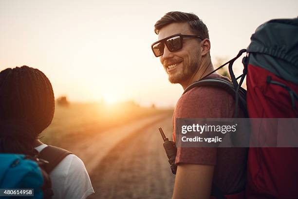 young smiling man hiking. - man looking back stock pictures, royalty-free photos & images