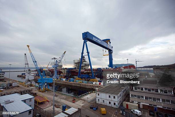 Dockyard crane stands over the Royal Navy's new Queen Elizabeth class aircraft carrier, manufactured by the Aircraft Carrier Alliance, a joint...