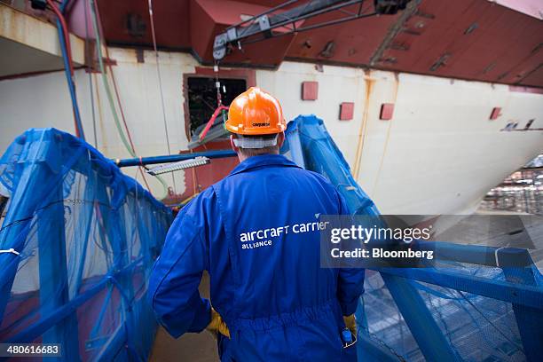 An Aircraft Carrier Alliance logo sits on a an employee's overalls as he works on the Royal Navy's new Queen Elizabeth class aircraft carrier,...