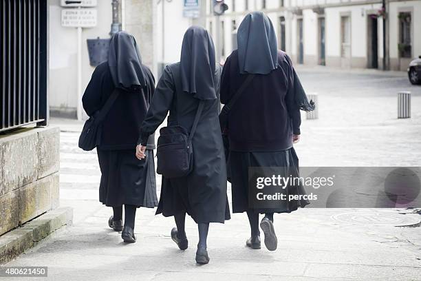 vista trasera de tres religiosas habían caminando en la calle. - spanish nun fotografías e imágenes de stock