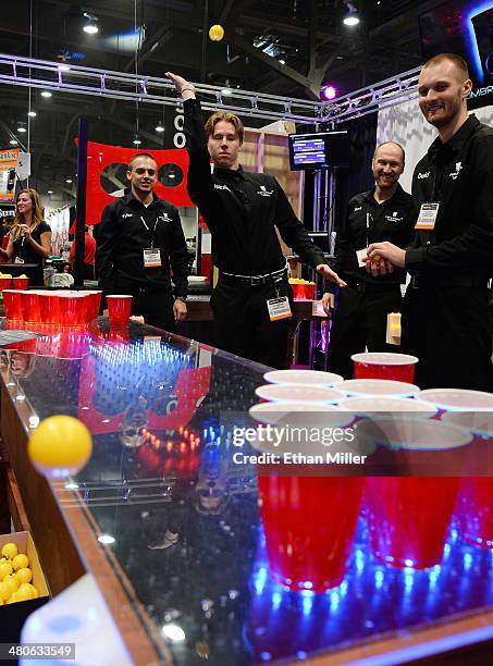 Attendees play beer pong at the Penumbra Tables booth at the 29th annual Nightclub & Bar Convention and Trade Show at the Las Vegas Convention Center...