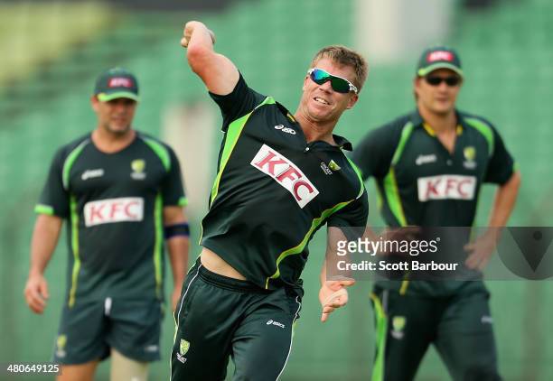 David Warner of Australia throws the ball as Brad Hodge and Shane Watson look on during an Australian ICC World Twenty20 Bangladesh 2014 training...