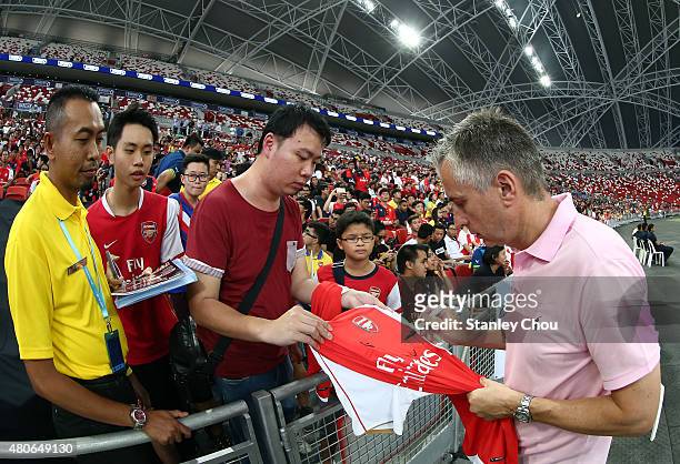 Former Arsenal legend Alan Smith signs autographs for fans during the Arsenal FC open training session ahead of the match between Arsenal and...