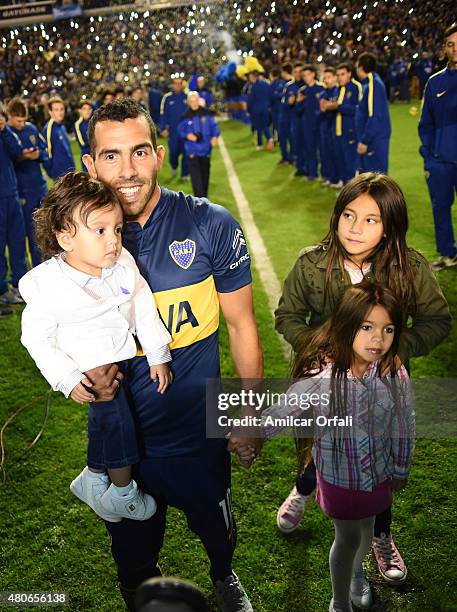 Carlos Tevez walks on the field with his daughters during his presentation as new player of Boca Juniors at Alberto J. Armando Stadium on July 13,...
